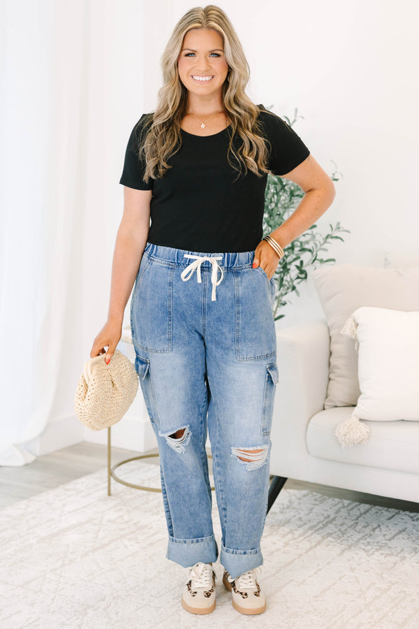Plus Size light wash cargo jeans with a drawstring waist, distressed knees, and utility pockets.