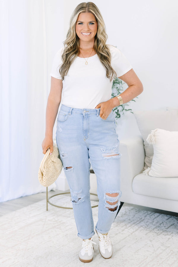 Plus Size light wash distressed jeans with a relaxed fit and rolled cuffs.
