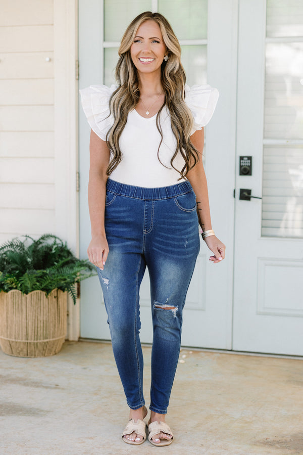 Plus Size medium wash distressed jeggings with an elastic waistband and a slim fit.