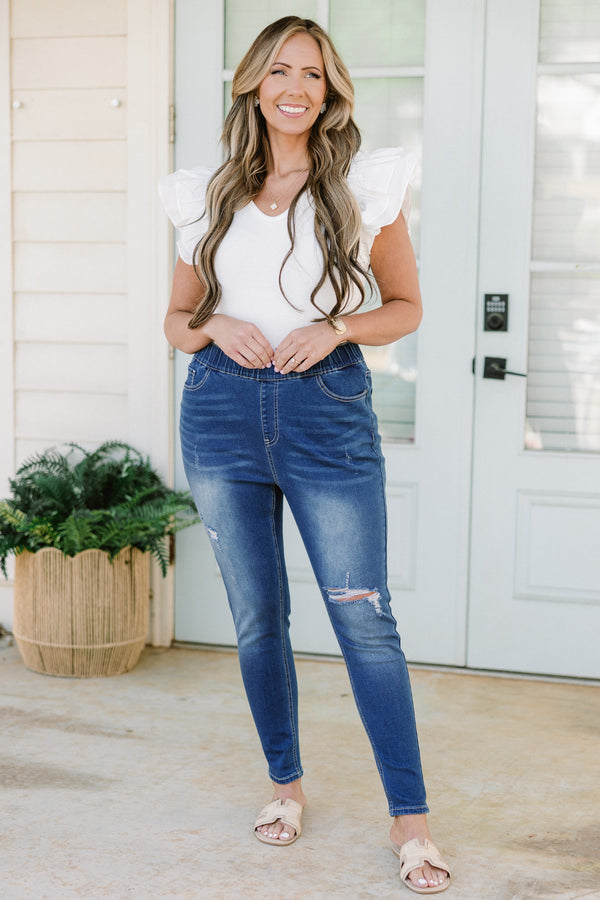 Plus Size medium wash distressed jeggings with an elastic waistband and a slim fit.
