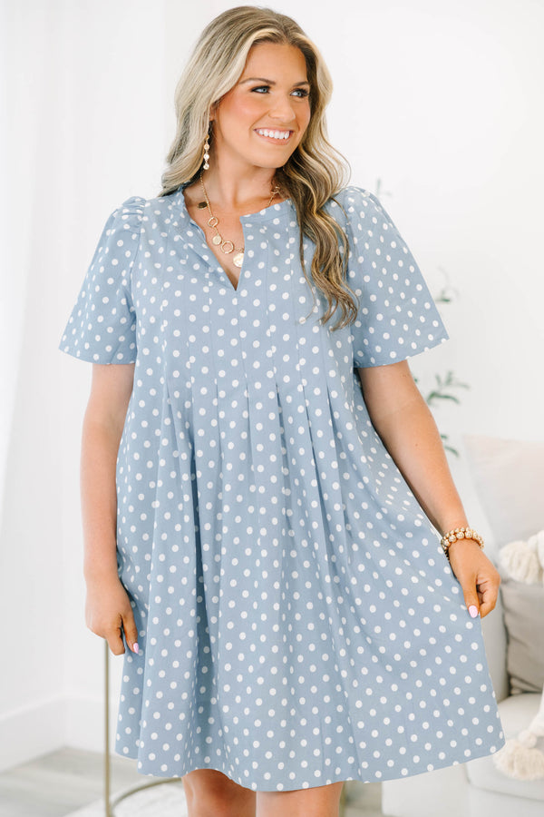 Plus Size blue polka dot dress with short puff sleeves, a V-neckline, and a flowy pleated skirt.