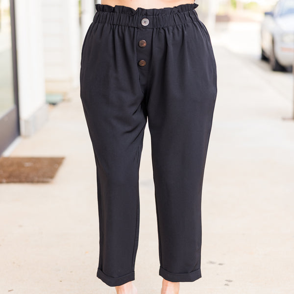 Plus Size black tapered work pants with a ruffled elastic waistband and decorative front buttons.