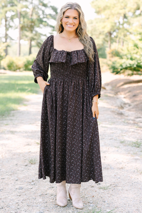 Plus size brown floral midi dress with a smocked waist, ruffled neckline, and flowy long sleeves.