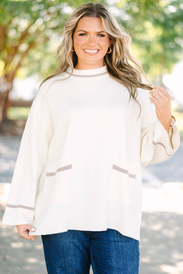 Plus Size ivory oversized sweater with a mock neck, wide sleeves, and tan stripe accents.