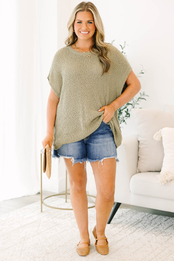 Plus size medium wash denim shorts with a button-fly front and frayed raw hem.