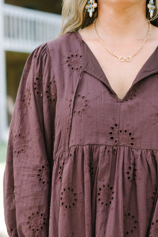 Plus Size brown cotton eyelet dress with a V-neckline, tie details, and long puff sleeves.