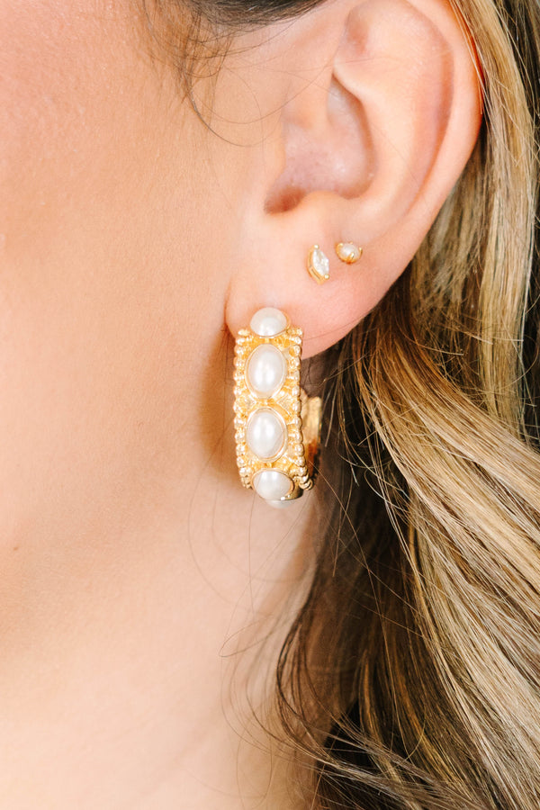 Close-up of a model wearing gold Honey Glow hoop earrings with white pearl accents.