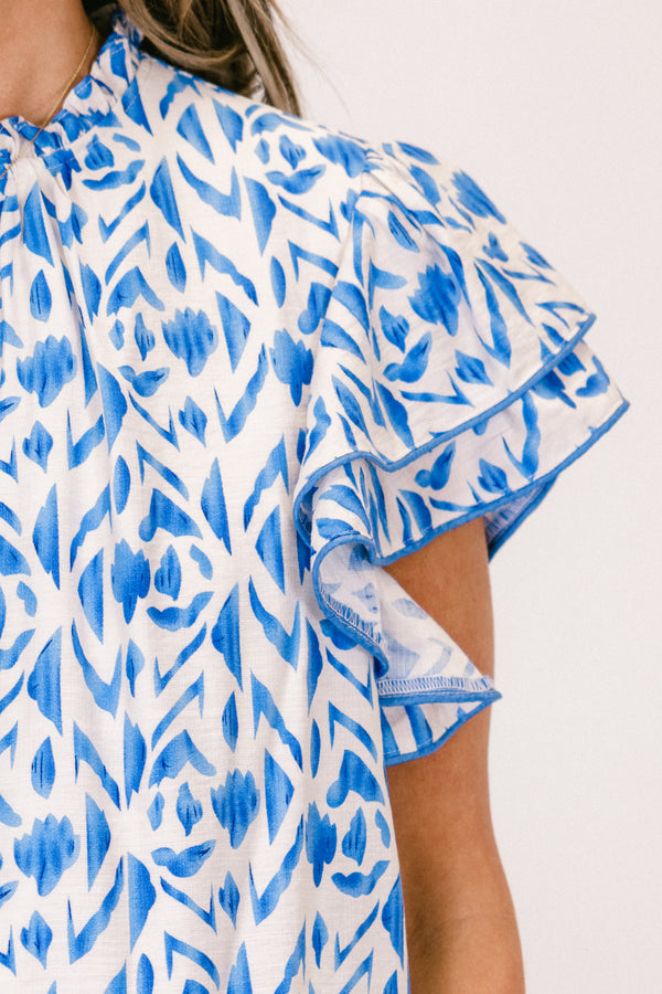 Plus Size blue and white abstract print top with flutter sleeves and a high neckline.

