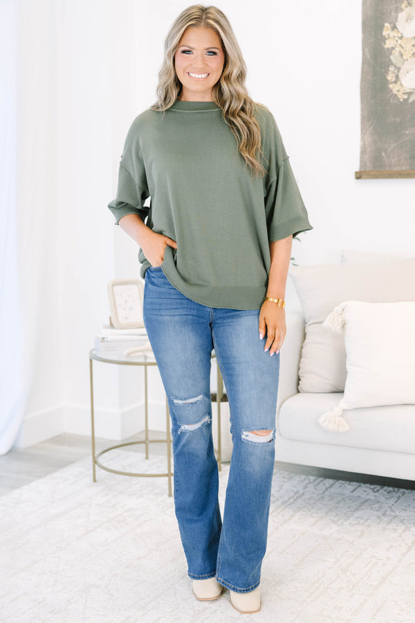 Plus size medium wash flare jeans with distressed knee details and a comfortable high-rise fit.