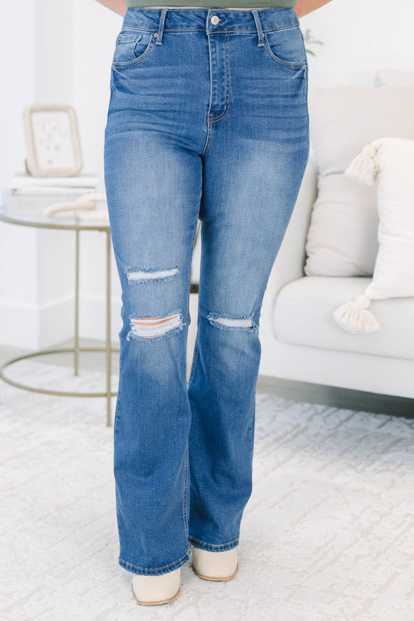 Plus size medium wash flare jeans with distressed knee details and a comfortable high-rise fit.