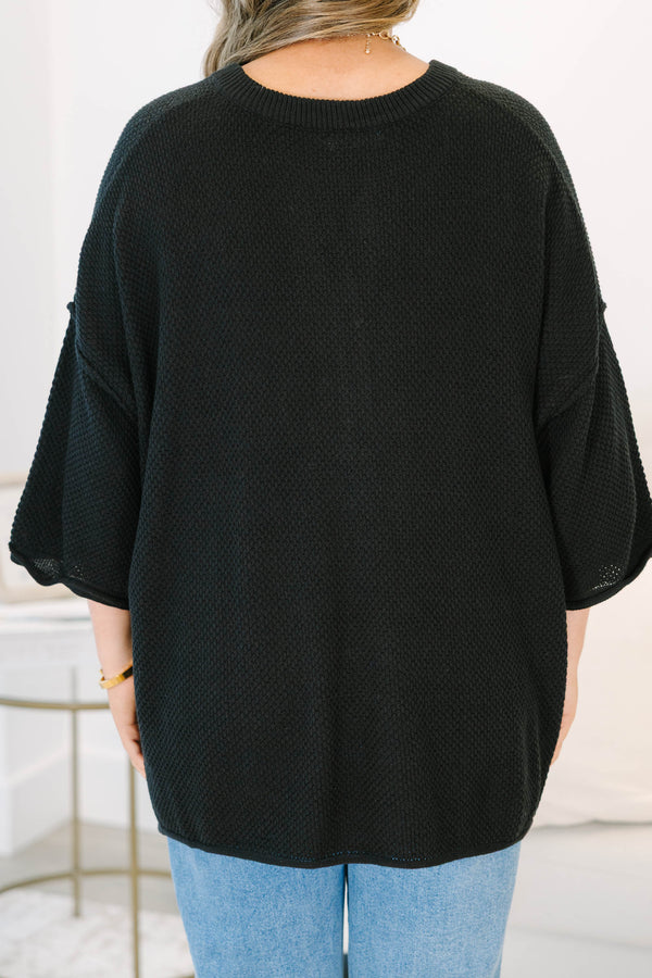 Plus Size black oversized knit top with a button-up henley neckline and three-quarter sleeves.