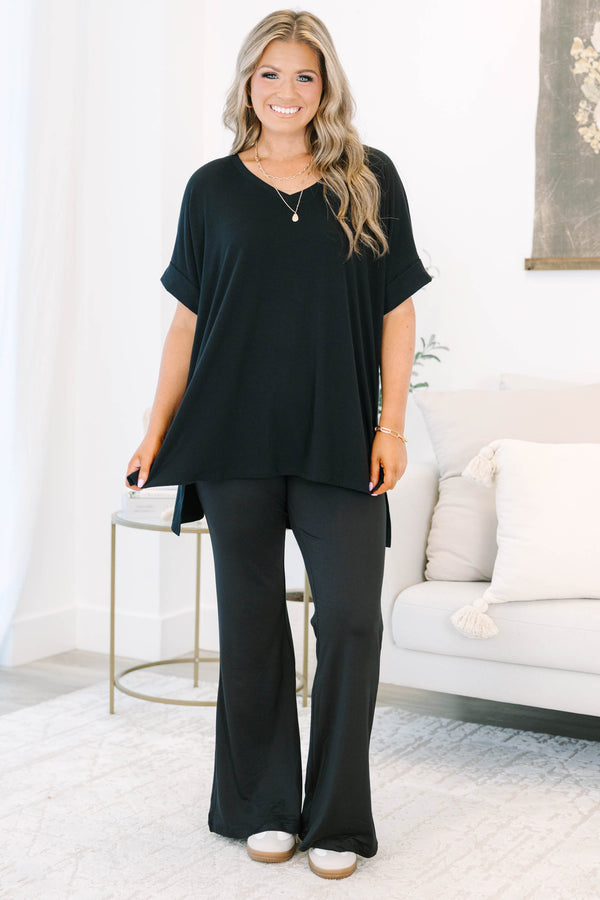 Plus size black flare leggings with a high-waisted, stretchy fit and flowy silhouette.