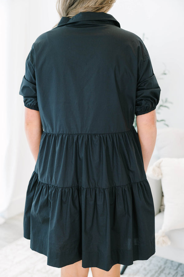 Plus size black cotton tiered shirt dress with short puff sleeves and a flowy, relaxed fit.
