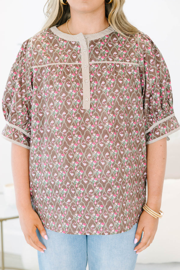 Plus Size brown floral top with puff sleeves, a striped henley neckline, and light wash jeans.