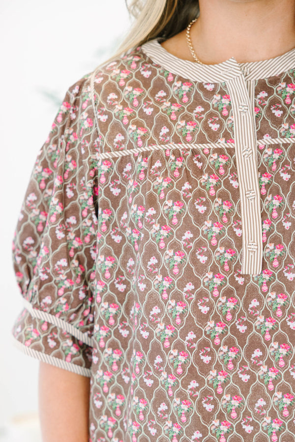 Plus Size brown floral top with puff sleeves, a striped henley neckline, and light wash jeans.