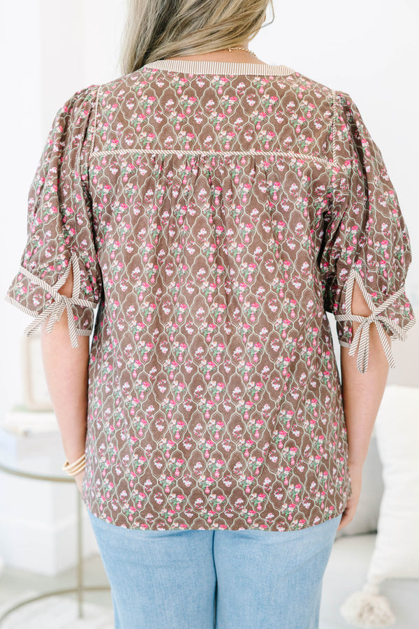 Plus Size brown floral top with puff sleeves, a striped henley neckline, and light wash jeans.