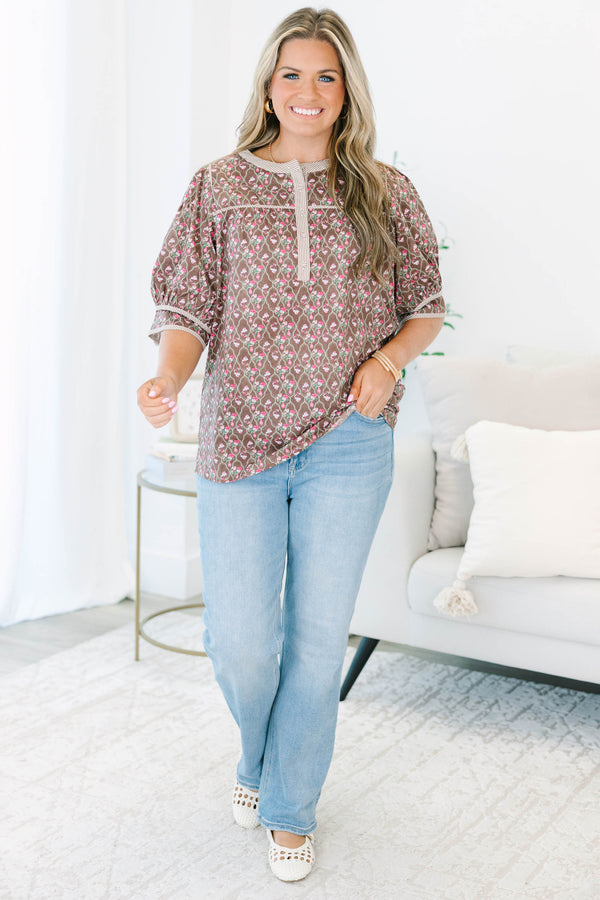 Plus Size brown floral top with puff sleeves, a striped henley neckline, and light wash jeans.
