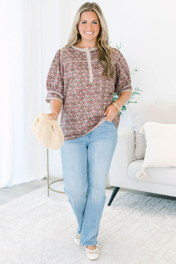 Plus Size brown floral top with puff sleeves, a striped henley neckline, and light wash jeans.