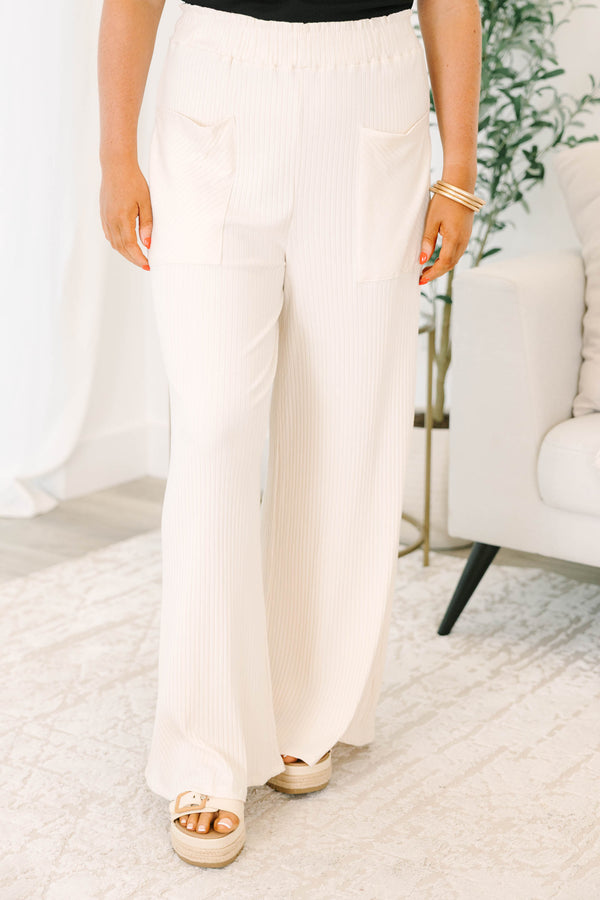 Plus size cream ribbed wide-leg pants with an elastic waist and front pockets for a flowy fit.