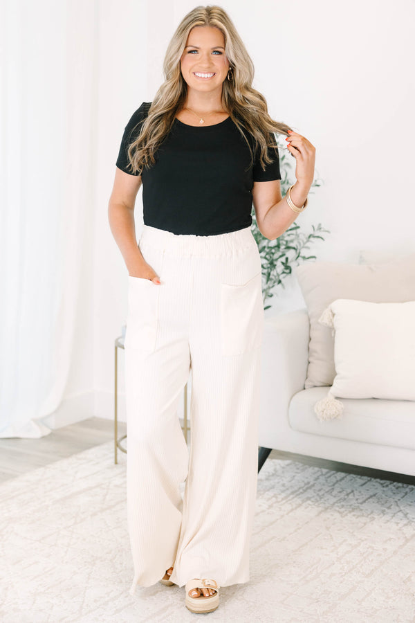 Plus size cream ribbed wide-leg pants with an elastic waist and front pockets for a flowy fit.