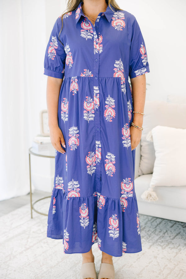 Plus size blue floral maxi dress with a flowy tiered skirt, button-down front, and short sleeves.