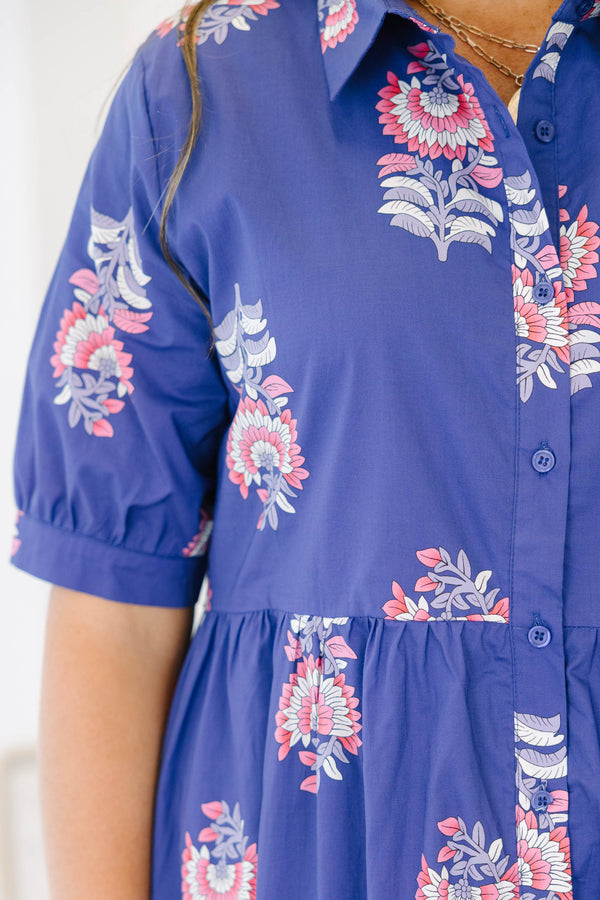 Plus size blue floral maxi dress with a flowy tiered skirt, button-down front, and short sleeves.