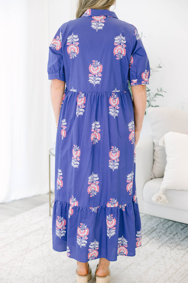 Plus size blue floral maxi dress with a flowy tiered skirt, button-down front, and short sleeves.