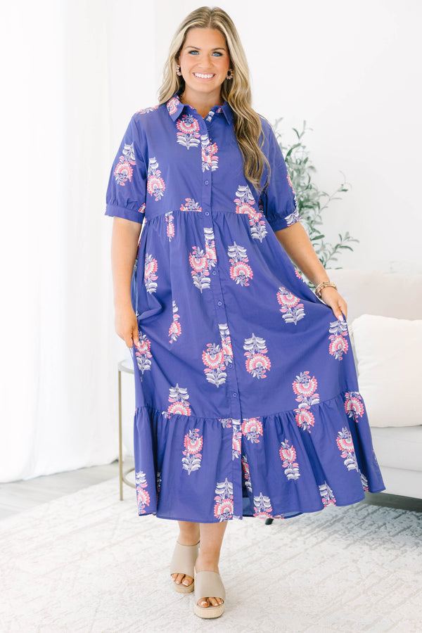Plus size blue floral maxi dress with a flowy tiered skirt, button-down front, and short sleeves.