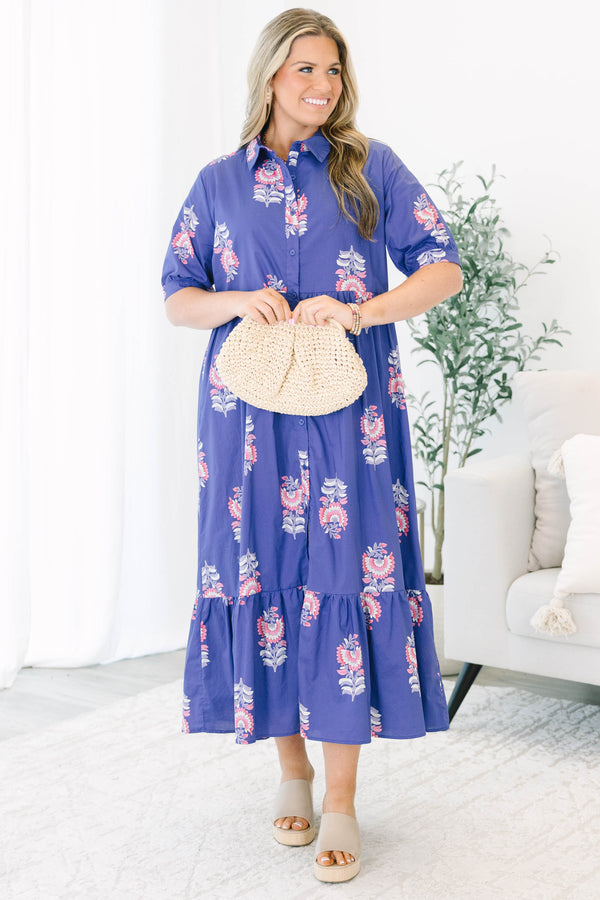 Plus size blue floral maxi dress with a flowy tiered skirt, button-down front, and short sleeves.