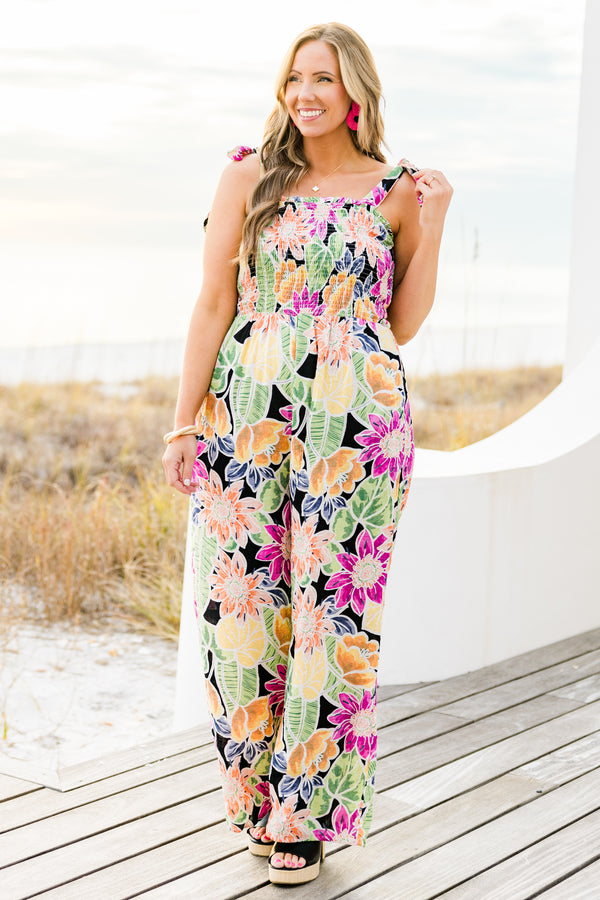 Chic Soul plus size clothing, black sleeveless flowy jumpsuit with a smocked bodice and tied straps with a multi-colored floral pattern