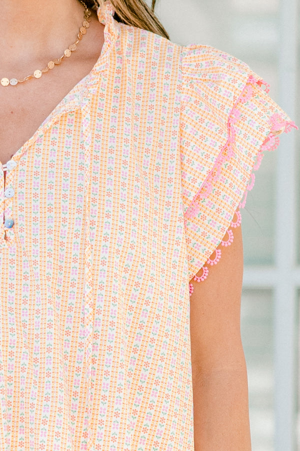Plus Size pink ditsy floral top with flutter sleeves, tassel ties, and functional buttons.