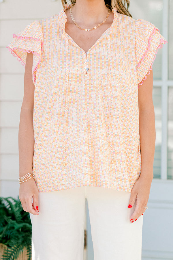 Plus Size pink ditsy floral top with flutter sleeves, tassel ties, and functional buttons.
