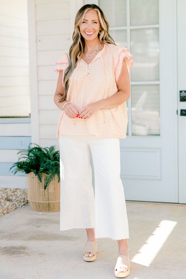 Plus Size pink ditsy floral top with flutter sleeves, tassel ties, and functional buttons.