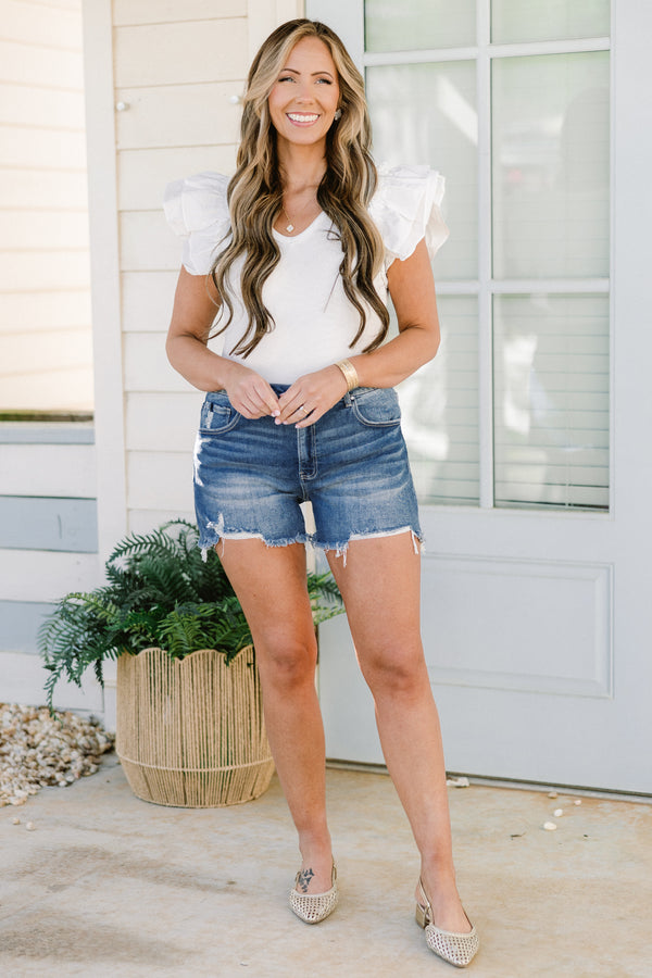 Chic Soul plus size clothing, mid-waisted medium wash denim distressed shorts with a silver button detail and a distressed hemline