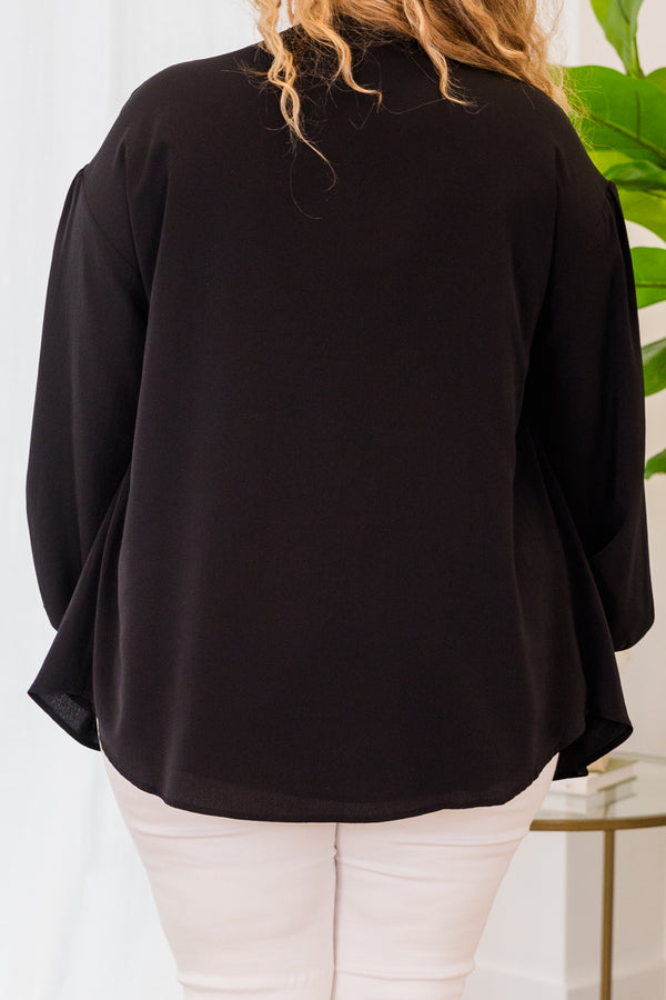 Plus Size black flowy top with long sleeves, a V-neckline, and a tassel tie detail.