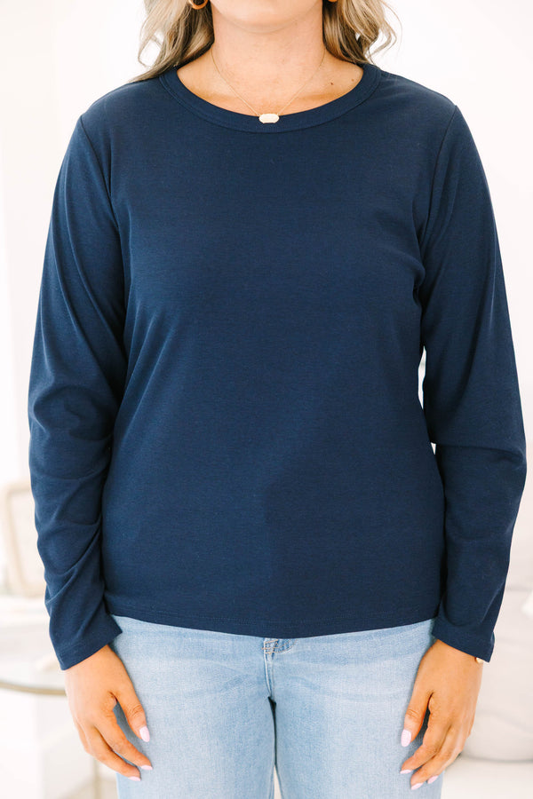Plus size woman in a navy long sleeve crewneck top with a soft, stretchy fit.