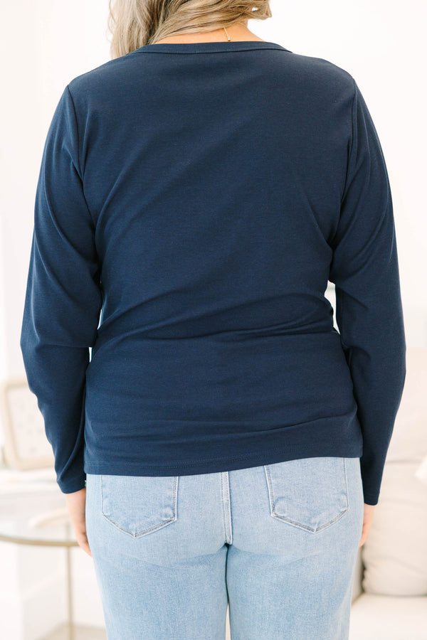 Plus size woman in a navy long sleeve crewneck top with a soft, stretchy fit.