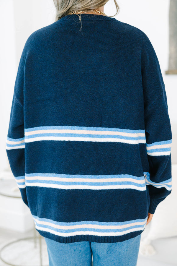 Plus Size navy blue crewneck sweater with horizontal light blue and white stripes and long sleeves.