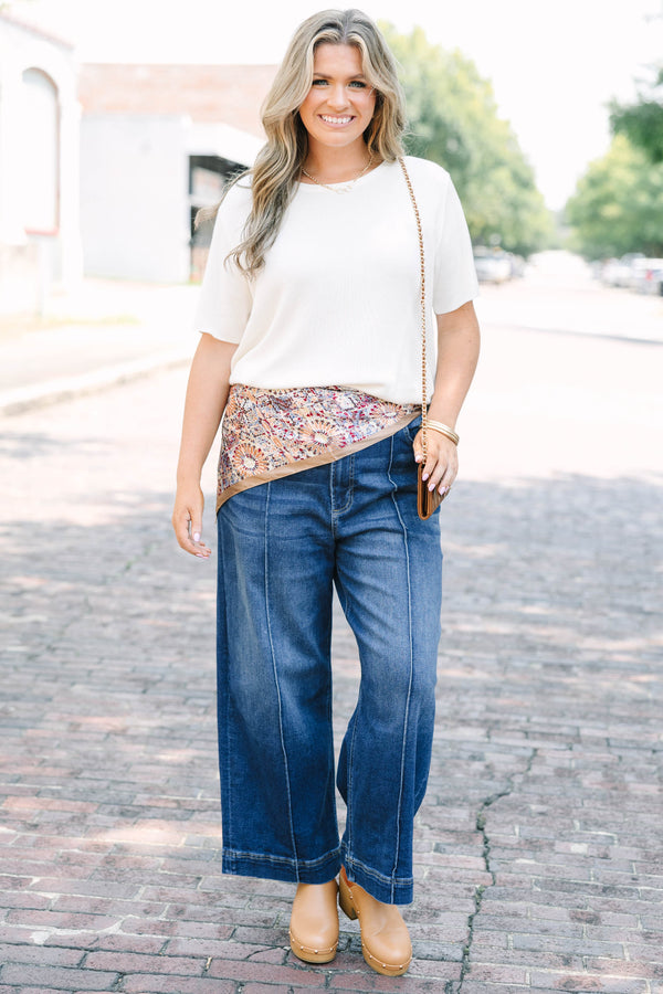 Plus Size high-rise, wide-leg dark wash jeans with front pintuck seams and a wide hem.