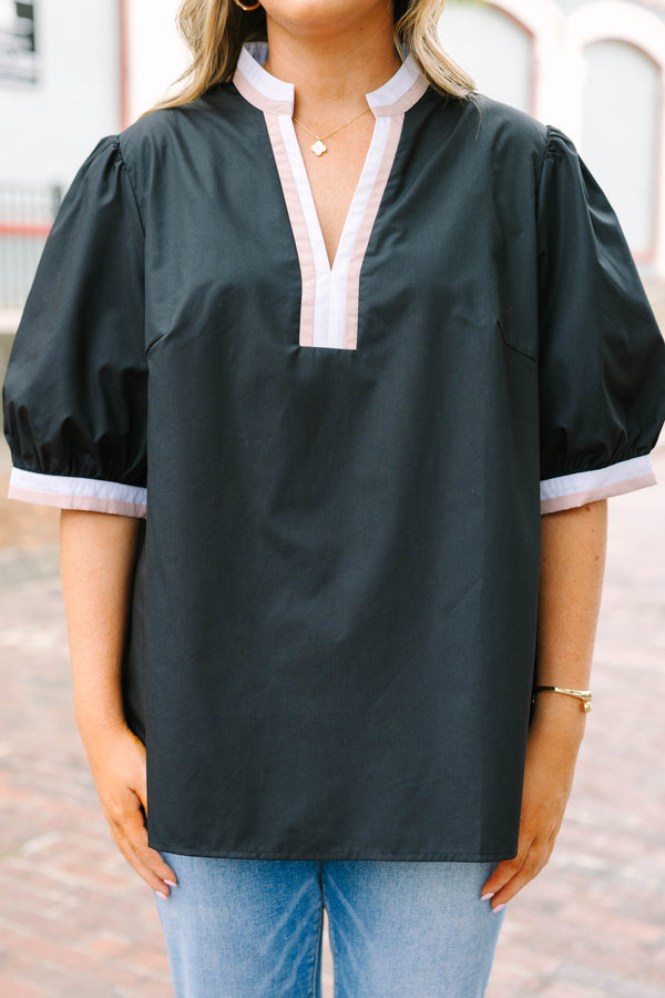 Plus Size black puff-sleeve top with a split v-neckline and cream and tan contrast trim.