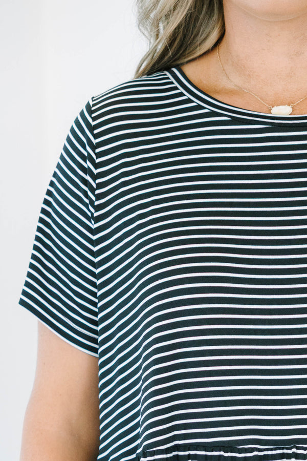 Plus size black and white striped babydoll dress with a flowy tiered skirt and short sleeves.