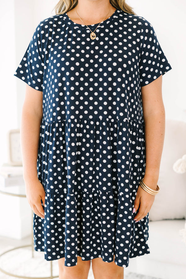 Plus Size navy polka dot babydoll dress with short sleeves, a round neckline, and tiered skirt.
