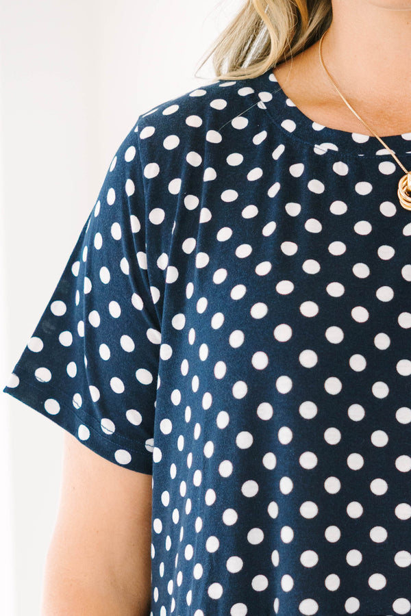 Plus Size navy polka dot babydoll dress with short sleeves, a round neckline, and tiered skirt.