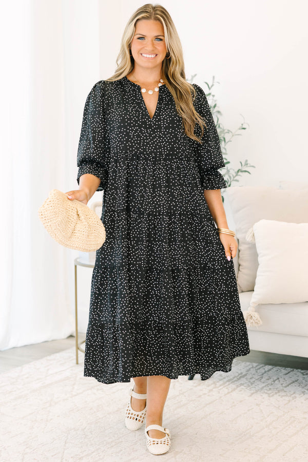 Plus size black polka dot tiered midi dress with a flowy fit and ruffled puff sleeves.