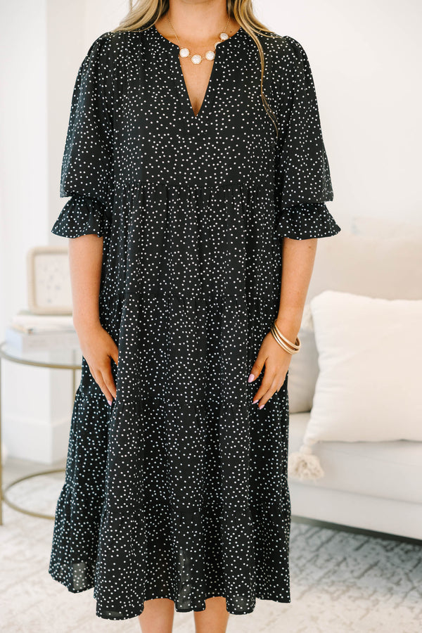 Plus size black polka dot tiered midi dress with a flowy fit and ruffled puff sleeves.