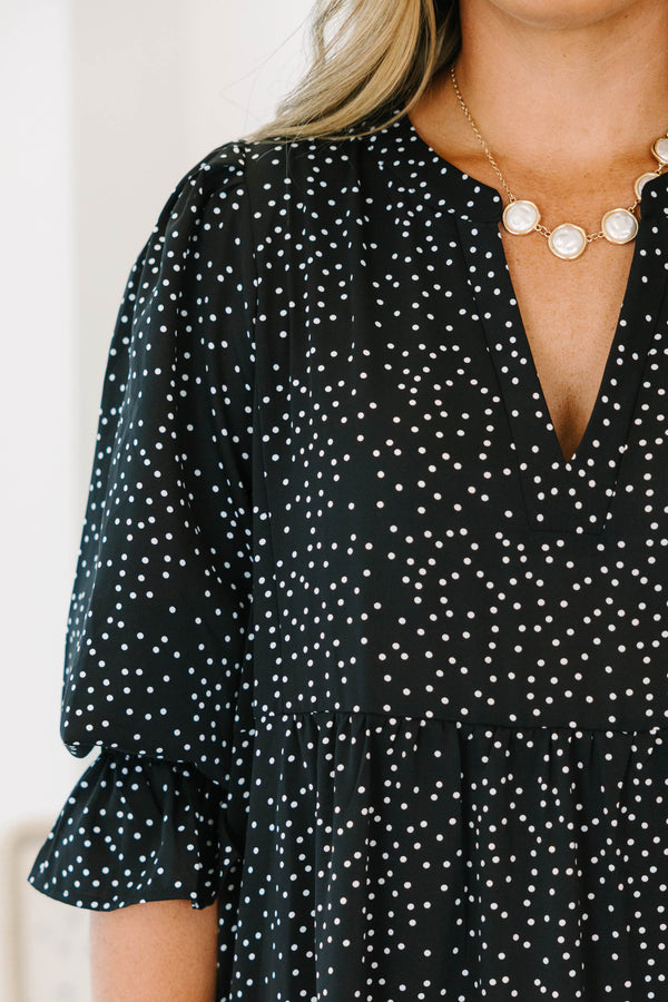 Plus size black polka dot tiered midi dress with a flowy fit and ruffled puff sleeves.