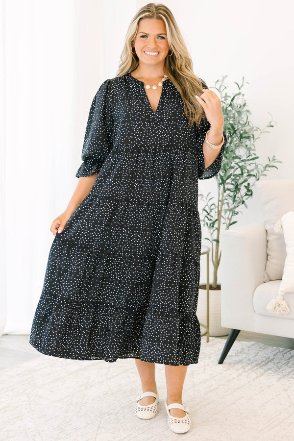 Plus size black polka dot tiered midi dress with a flowy fit and ruffled puff sleeves.