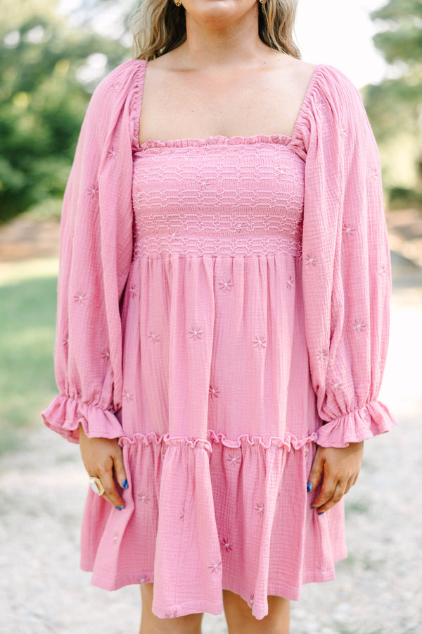 Plus size pink cotton dress with smocked bodice, long puff sleeves, and floral embroidery.