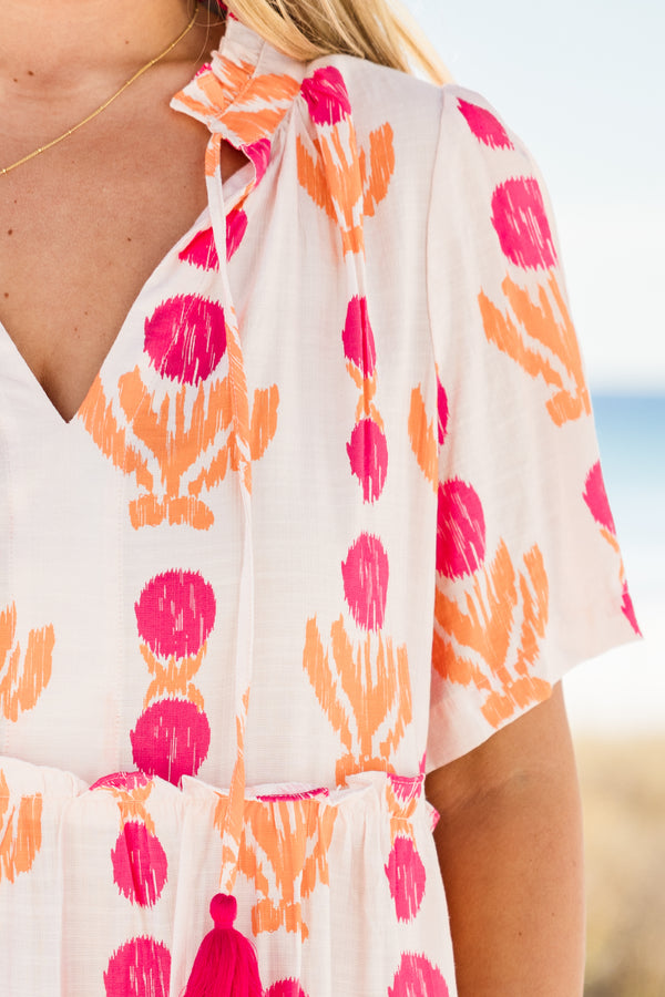 Chic Soul plus size clothing, short-sleeve white flowy baby doll dress with a split-v-neckline and tassels with a hot pink pom at the end with a hot pink and orange abstract striped pattern 
