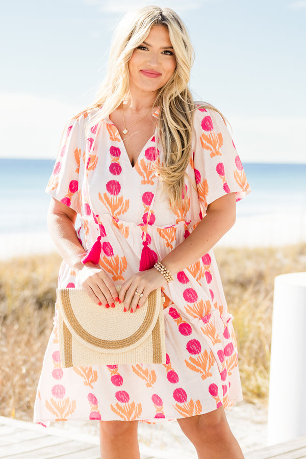 Chic Soul plus size clothing, short-sleeve white flowy baby doll dress with a split-v-neckline and tassels with a hot pink pom at the end with a hot pink and orange abstract striped pattern 